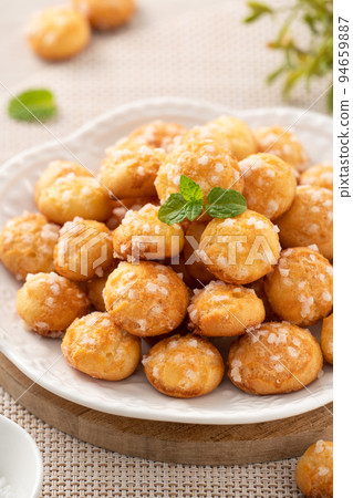 Delicious French Chouquette Choux Pastry dessert Pearl Sugar Puff on wooden table background. 94659887