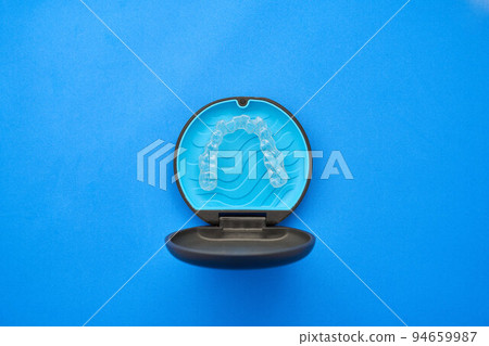 A transparent, invisible aligner or brace used in orthodontics and its container 94659987