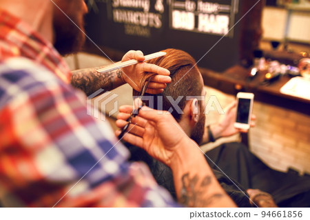 Time for a new hairdo. Handsome young bearded man came to the barber for a haircut. hipster style. 94661856