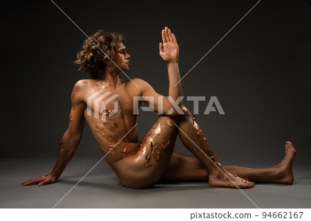 Naked young man doing Seated Spinal Twist pose 94662167