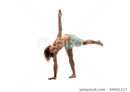 Shirtless young man doing Half Moon pose 94662217