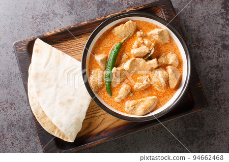 Kukul mas is a traditional Sri Lankan chicken curry made with a onions, ginger, garlic, turmeric, garam masala, chili powder, coconut milk, tomato. Horizontal top view 94662468