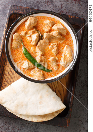 Sri Lankan Chicken Curry Kukul Mas with coconut milk and aromatic spices closeup in the bowl. Vertical top view Sri Lankan Chicken Curry Kukul Mas with coconut milk and aromatic spices closeup in the bowl. Vertical top view 94662471