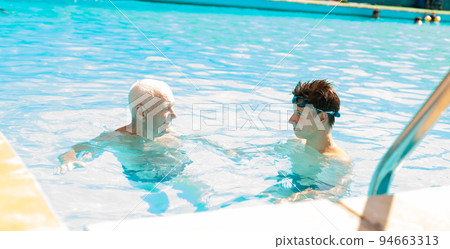 sports grandfather and grandson communicate in swimming pool sports grandfather and grandson communicate in swimming pool 94663313