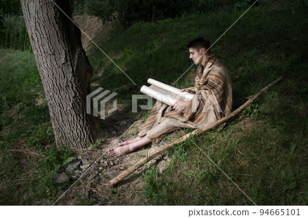 Man sitting on the grass and reading book Man sitting on the grass and reading book 94665101