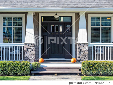 Decorative ripe pumpkins laying in front the house entrance 94665996