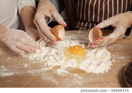Mother and her daughter are baking a bread and having fun at the kitchen. Mother and her daughter are baking a bread and having fun at the kitchen. 94666355