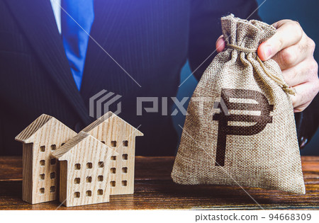 Philippine peso money bags and residential buildings figures. Taxes. Bank offer of mortgage loan. Investments in real estate and construction industry. Rental. Sale of housing. Buy. Municipal budget. 94668309