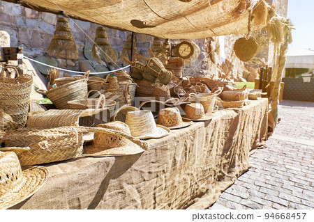 Outdoor market stall selling straw hats 94668457