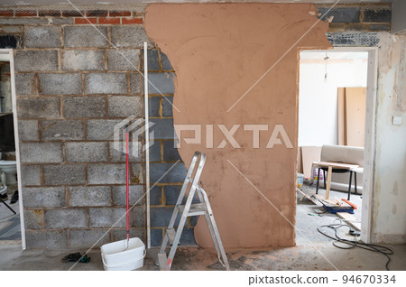 Plastering of concrete block wall. making the wall even with brown plaster 94670334