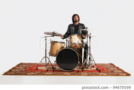 Studio shot of young musician with drums performing over white background. Concept of music, hobby, festival, entertainment 94670599