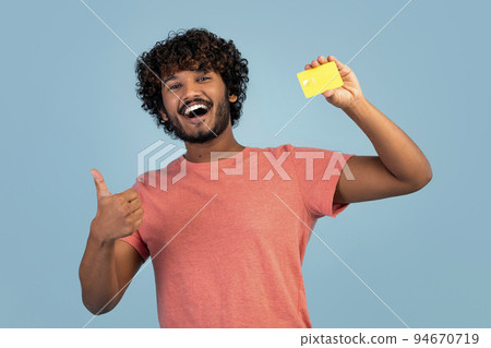 Happy eastern guy showing credit card and thumb up Happy eastern guy showing credit card and thumb up 94670719
