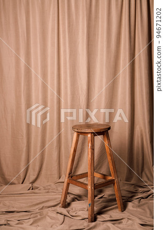 Wooden bar stool on a fabric brown background 94671202