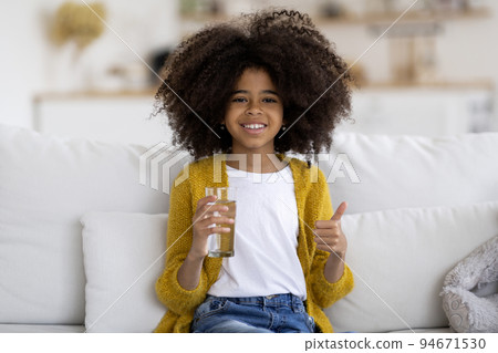 Happy little black girl drinking water, showing thumb up 94671530