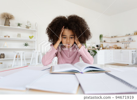 Overwhelmed african american school girl doing homework, feeling down 94671919