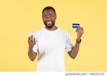 African Guy Shopping Via Phone And Credit Card In Studio African Guy Shopping Via Phone And Credit Card In Studio 94672213