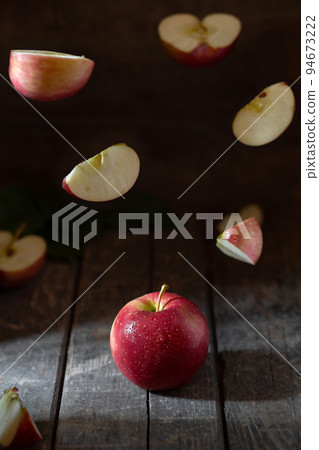 Apple levitation red, cut pieces fly on a wooden background 94673222