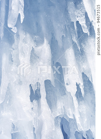 Blue ice and icicles on the rocks of Ogoy island, Baikal lake, Siberia, Russia. Abstract winter nature background. Blue ice and icicles on the rocks of Ogoy island, Baikal lake, Siberia, Russia. Abstract winter nature background. 94673515