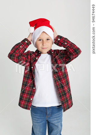 A boy with a white background holds a musical instrument in the New Year's room. A boy with a white background holds a musical instrument in the New Year's room. 94674449