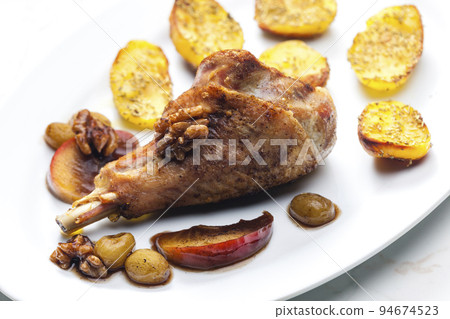 poultry leg baked with fruit and walnuts served with fried potatoes poultry leg baked with fruit and walnuts served with fried potatoes 94674523