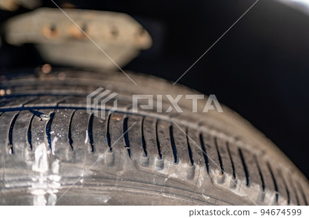 screw protruding from the tread of a tire causing a flat. 94674599