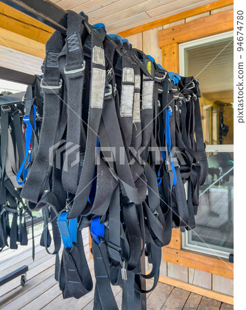 Row of harnesses ready for use at a high ropes and climbing course.  94674780