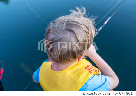 Boy on a fishing with blue water in background Boy on a fishing with blue water in background 94674801