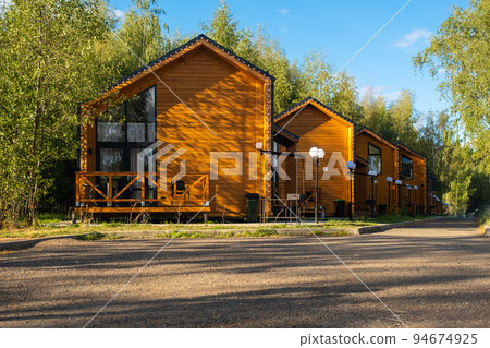 A group of barn-style houses. Modern stylish houses in the sun. Blue sky A group of barn-style houses. Modern stylish houses in the sun. Blue sky 94674925