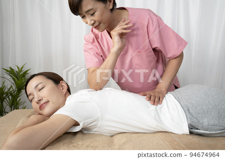 woman receiving a back massage 94674964