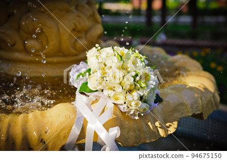 The Wedding Bridal Bouquet Of White Roses Lies In An Old Fountain Under Splashes And Drops Of Water. 94675150