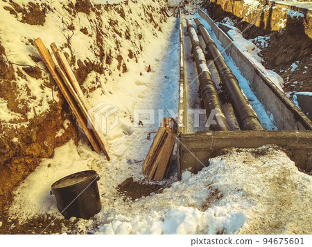 long, thin, black, narrow pipes for laying plumbing communications. polypropylene pipes are laid in the ground to drain sewage from residential buildings long, thin, black, narrow pipes for laying plumbing communications. polypropylene pipes are laid in the ground to drain sewage from residential buildings 94675601