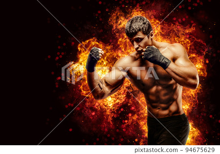 Fighter man punching in fire 94675629