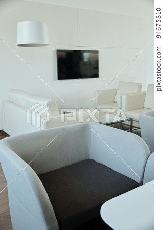 Black and grey comfortable velvet armchair standing in front of camera in office Black and grey comfortable velvet armchair standing in front of camera in office 94675810