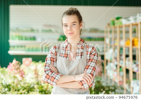 Ai generated face of young pretty farmer or shop assistant with crossed arms 94675976