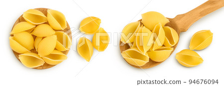 Uncooked dried conchiglie in spoon. Raw shell pasta isolated on white bachground with full depth of field. Top view. Flat lay Uncooked dried conchiglie in spoon. Raw shell pasta isolated on white bachground with full depth of field. Top view. Flat lay 94676094