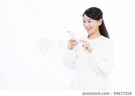 A woman in her 30s searching on a smartphone A woman in her 30s searching on a smartphone 94677826