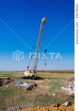 Big Power Mobile Crane on a road and tower crane in construction site Big Power Mobile Crane on a road and tower crane in construction site 94678083