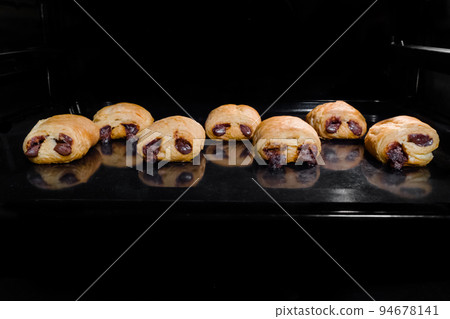 Seven baked mini homemade buns with chocolate filling - front view 94678141