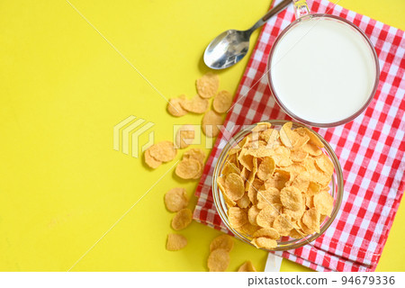 cornflakes bowl breakfast food and snack for healthy food concept, morning breakfast fresh whole grain cereal, cornflakes with milk on yellow background 94679336