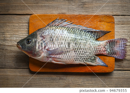 Tilapia on wooden cutting board background, Fresh raw tilapia fish from the tilapia farm 94679355