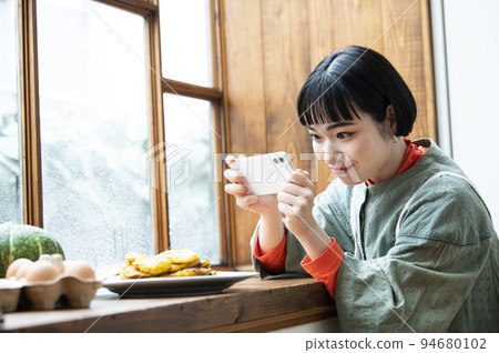 年輕女子為自製煎餅拍照 年輕女子為自製煎餅拍照 94680102