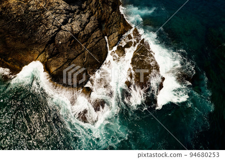 Aerial view of waves crashing on rocks,Seascape birds eye view photo shot over ocean waves, Image for nature background and travel background,Amazing seashore at Phuket island thailand 94680253