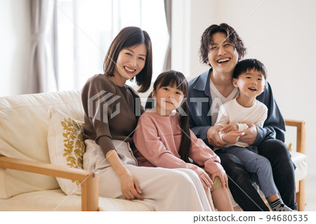 坐在沙發上微笑的家庭/育兒形象 坐在沙發上微笑的家庭/育兒形象 94680535