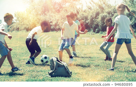 Group of kids are running and playing football in the park Group of kids are running and playing football in the park 94680895