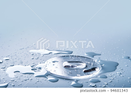 Cosmetic product drops and in glass slide on blue background, selective focus 94681343