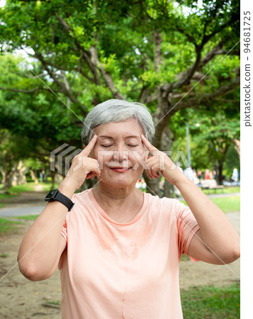 A 60-year-old Asian mature woman with a massage eye, enjoying the fresh air of nature in the park. A 60-year-old Asian mature woman with a massage eye, enjoying the fresh air of nature in the park. 94681725