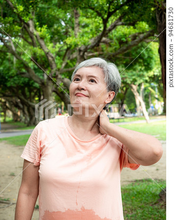Mature Asian woman in her 60s is uncomfortable with sore shoulders exercising outdoors Mature Asian woman in her 60s is uncomfortable with sore shoulders exercising outdoors 94681730