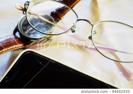 Glasses, wristwatch and smartphone on a white table Glasses, wristwatch and smartphone on a white table 94682030