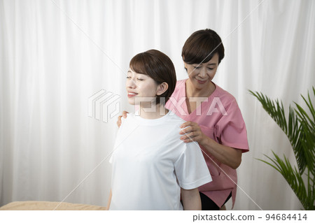 A woman who receives a manipulative treatment and a woman who is a manipulative therapist A woman who receives a manipulative treatment and a woman who is a manipulative therapist 94684414