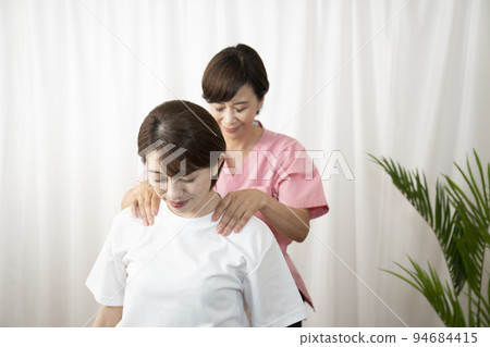 A woman who receives a manipulative treatment and a woman who is a manipulative therapist A woman who receives a manipulative treatment and a woman who is a manipulative therapist 94684415